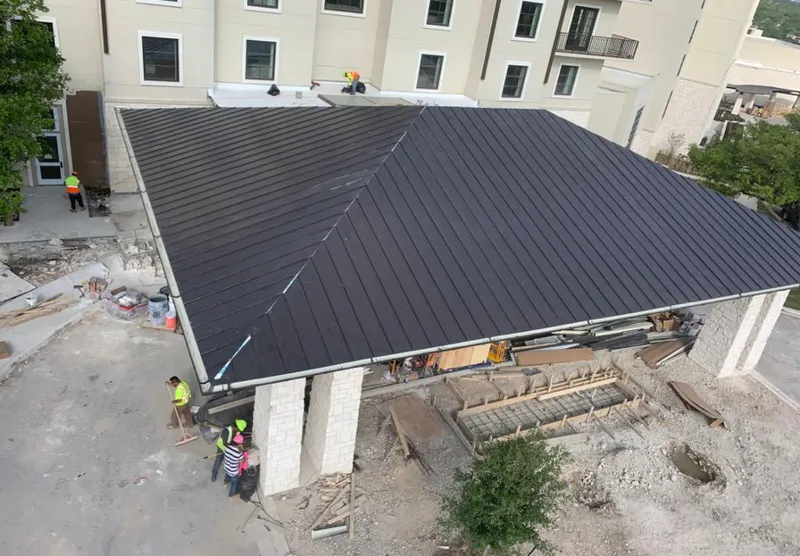 Metal roofing installation team working on a commercial building in Prichard